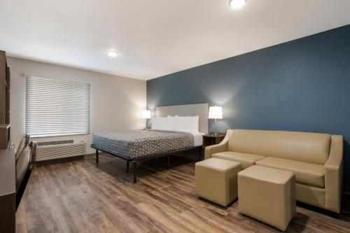 Habitación con cama y sofá en una habitación en WoodSpring Suites Indio - Coachella Valley, en Indio