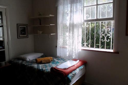a small bed in a room with a window at Muqui91 in Teresópolis
