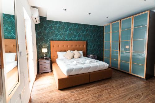 a bedroom with a bed and a green wall at Penthouse Suite 9 at Palazzo Seraphim Boutique living in St Julians in St Julian's