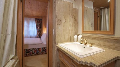 uma casa de banho com um lavatório e um espelho em Chalet Kisseye em Zermatt