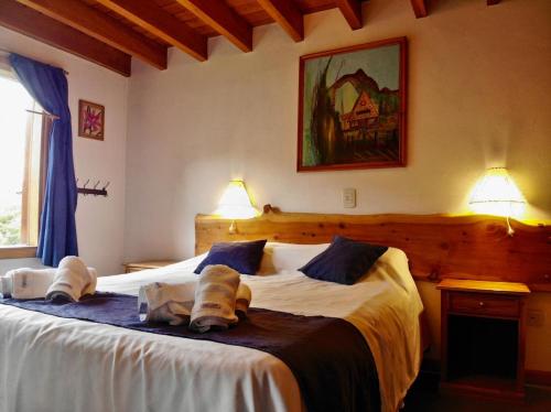 a bedroom with a large bed with two pillows at Apart Hotel del Pellin in San Martín de los Andes