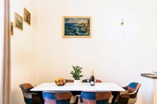 einen Tisch mit Stühlen und eine Flasche Wein in der Unterkunft City center apartment Azura Vista in Poreč