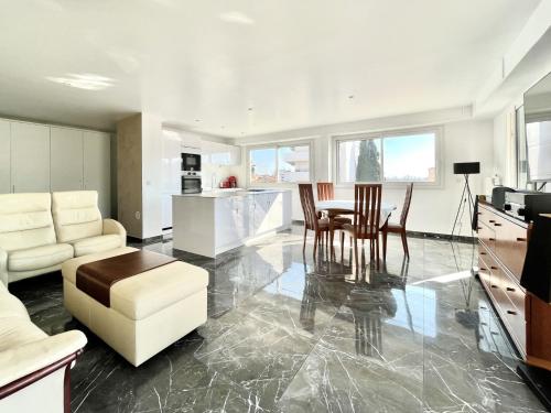 une cuisine et un salon avec une table et des chaises dans l'établissement Le Panoramique - 4 pièces centre Cannes, à Cannes