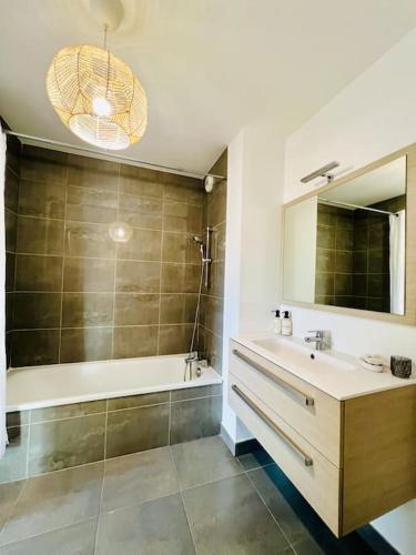 une salle de bain avec un lavabo, une douche et un miroir dans l'établissement T3 cosy proche mer avec Parking, à Villeneuve-lès-Maguelone