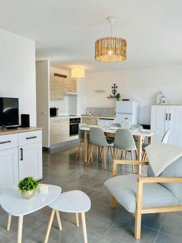 une cuisine et un salon avec une table et des chaises dans l'établissement T3 cosy proche mer avec Parking, à Villeneuve-lès-Maguelone