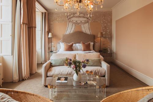 a bedroom with a bed and a table with flowers on it at No 15 by GuestHouse, Bath in Bath