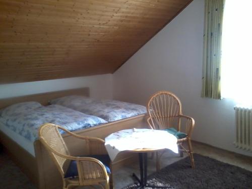 a bedroom with a bed and two chairs and a table at Pension Familie Schwarz GbR in Alhausen