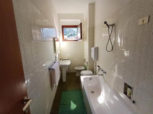 a bathroom with a tub and a toilet and a sink at Diana Cosy Apartment sea view near the beach in Monterosso al Mare