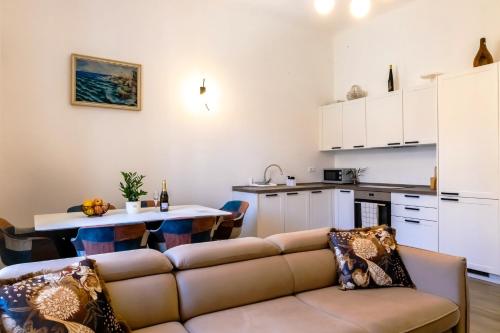 ein Wohnzimmer mit einem Sofa und einer Küche in der Unterkunft City center apartment Azura Vista in Poreč