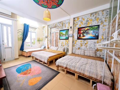 Habitación con 2 camas, sofá y TV. en H2 homestay phố cổ check in tự động, en Hanói