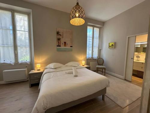- une chambre avec un grand lit blanc et un lustre dans l'établissement C025 Villa Toscane Bel Appartement Bourgeois, à Cannes