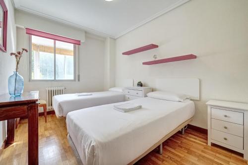 パンプローナにあるCamino Pamplona 3 by Clabaoのベッドルーム1室(ベッド2台、デスク、窓付)