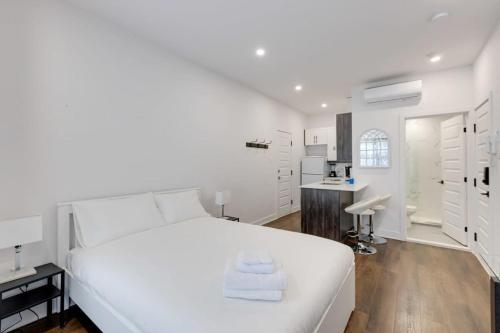 a white bedroom with a white bed and a bathroom at M11 Upscale Studio wQueen Bed AC Prime Location in Montréal