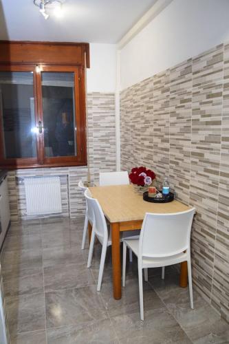 a dining room with a wooden table and white chairs at Ca Aisha Train Station Venice in Mestre
