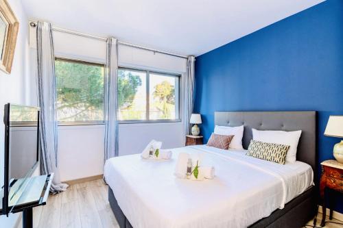 une chambre avec un grand lit avec un mur bleu dans l'établissement L'Étrier-Cannes Centre Terrasse, à Cannes