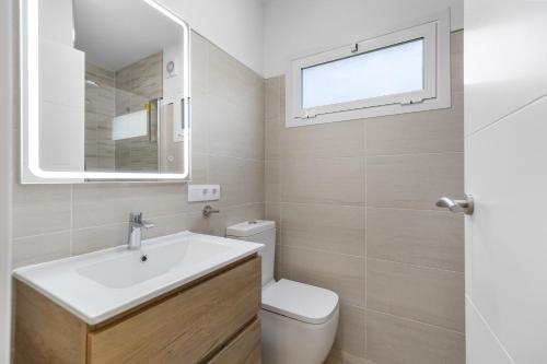 a bathroom with a sink and a toilet and a window at VILLA Henry in Playa de Palma