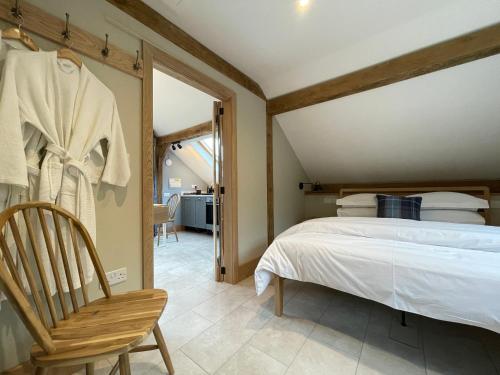 a bedroom with a bed and a chair at Lancasters Cottage in Horsham