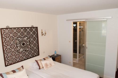 a bedroom with a bed and a glass shower at La Chaumière Roz-Aven in Pont-Aven