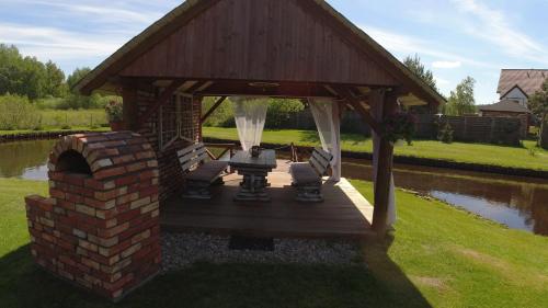 a gazebo with chairs and a table and a brick wall at Kaszuby wczasy u Danusi sauna i bania in Lipusz