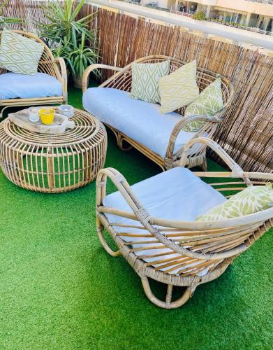 2 rieten stoelen en een tafel op een patio bij Riviera’s Soul in Antibes