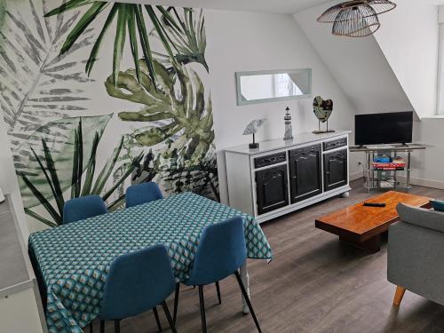une salle à manger avec une table et des chaises bleues dans l'établissement La maison rouge, au Guilvinec