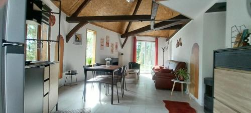 une cuisine et un salon avec une table et des chaises dans l'établissement Le manège terre et mer proche Etretat, à Gonneville-la-Mallet
