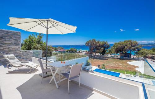 a patio with a table and chairs and an umbrella at Beach Front Home In Punat With Kitchen in Punat