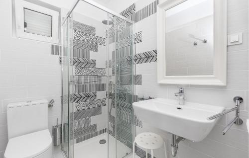 a white bathroom with a sink and a mirror at Beach Front Home In Punat With Kitchen in Punat