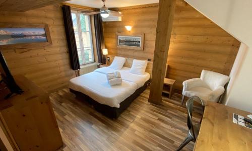 a bedroom with a bed and a chair in a room at Le Moulin de Lily in Palaiseau