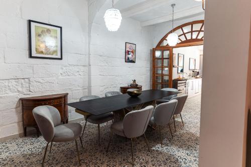 a dining room with a black table and chairs at Suite 3 at Palazzo Seraphim Boutique living in St Julians in St Julian's