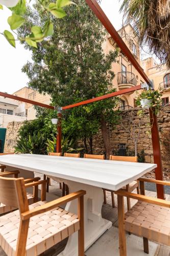 a large white table and chairs on a patio at Suite 3 at Palazzo Seraphim Boutique living in St Julians in St Julian's