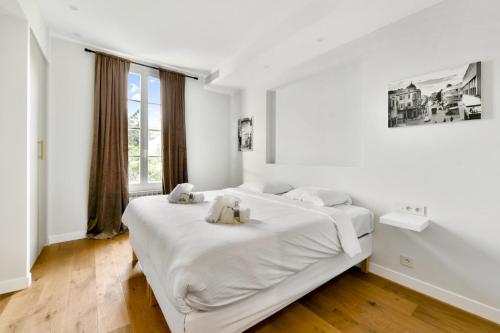 una camera da letto bianca con un letto con due orsacchiotti sopra di Villa Léon - Centre Cannes - 4 chambres - Clim a Cannes