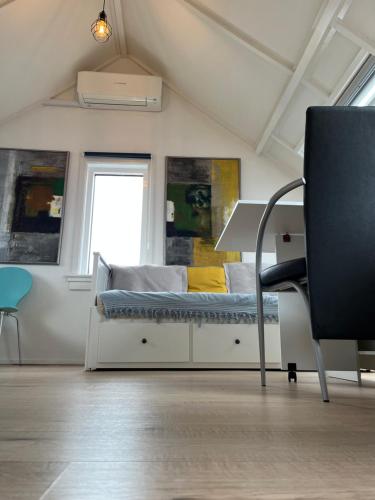 奈梅亨的住宿－Studio met eigen badkamer en eigen keuken，卧室配有床、椅子和窗户。