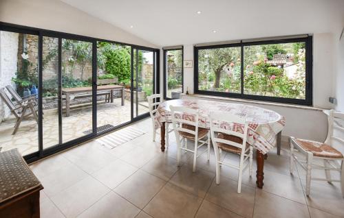 une salle à manger avec une table, des chaises et des fenêtres dans l'établissement Stunning Home In Villes-Sur-Auzon, à Villes-sur-Auzon