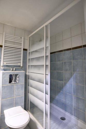 a bathroom with a toilet and a glass shower at Le Moulin de Lily in Palaiseau