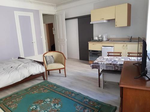 a room with a bed and a table and a kitchen at Tradition Plombières in Plombières-les-Bains