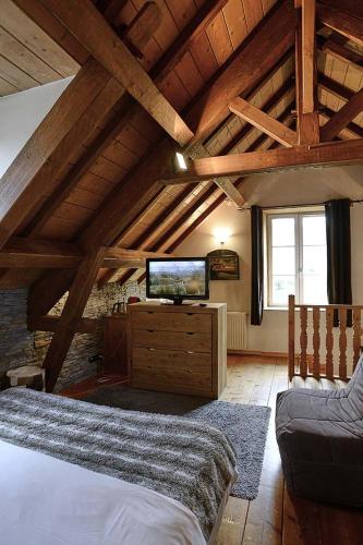 a bedroom with a bed and a tv on a dresser at Le Moulin de Lily in Palaiseau