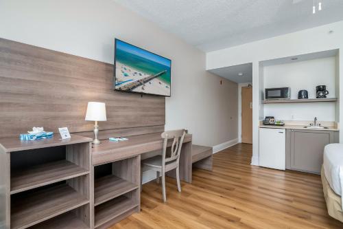 a bedroom with a desk and a bed and a kitchen at Naples Park Central Hotel in Naples