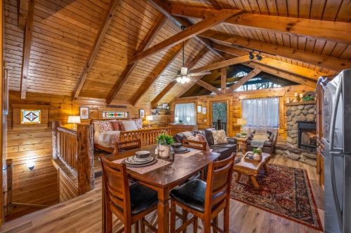 a dining room and living room in a log cabin at Log Cabin, Hot Tub, Fireplace, Pool Table & Views! in Sevierville