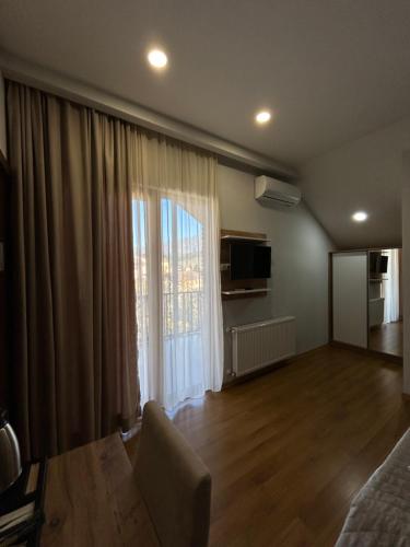 a living room with a large window and a couch at 10 KEYS Boutique Hotel in Borjomi