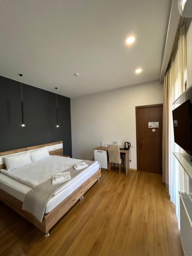 um quarto com uma cama grande e uma mesa em 10 KEYS Boutique Hotel em Borjomi