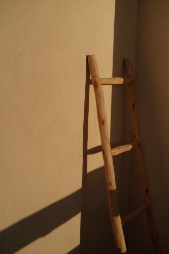 a wooden ladder leaning against a wall at Loued Surf Lodge in Imsouane