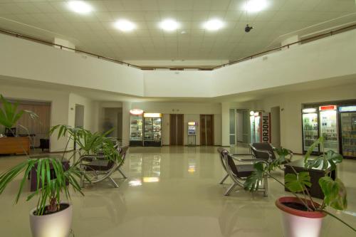 an empty lobby with chairs and plants at Hotel Rustavi in Rustavi