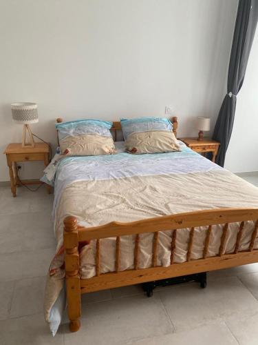 - une chambre avec un lit en bois et 2 oreillers dans l'établissement Ville à la mer, à Cancale