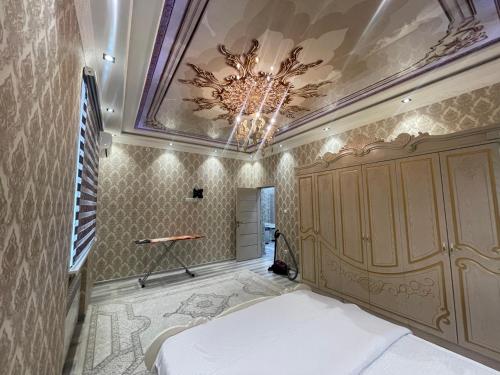 um quarto com uma cama e um tecto com um lustre em Cozy apartment 3 em Samarkand
