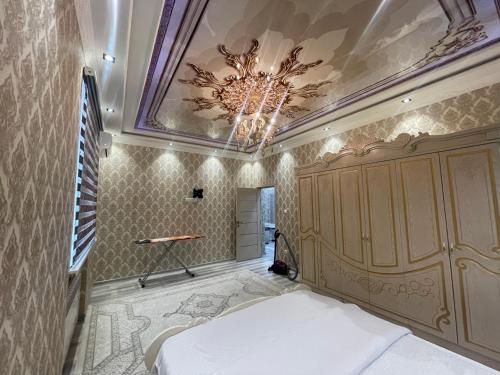 een slaapkamer met een bed en een plafond met een kroonluchter bij Cozy apartment 3 in Samarkand