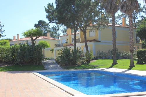 a house with a swimming pool in front of a building at D. Sebastião Townhouse in Casal da Lagoa Seca