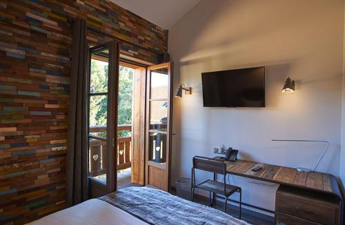 a bedroom with a bed and a desk with a television at Le Moulin de Lily in Palaiseau