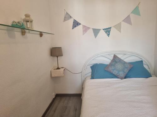 Schlafzimmer mit einem Bett mit blauen Kissen und Flaggen an der Wand in der Unterkunft 408-apartamento vistas canal in Empuriabrava