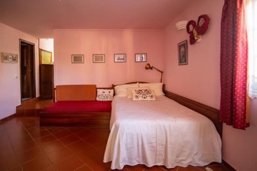 - une chambre avec un lit blanc et un banc rouge dans l'établissement Private Art Studio 50m from sea (1-4 per), à Monemvasia